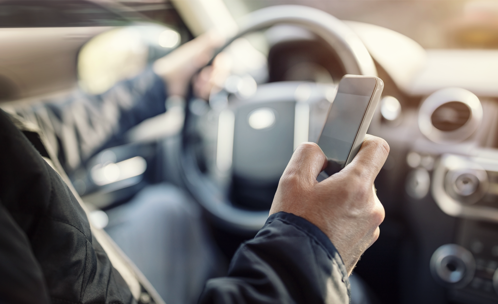 Cell phone being used while driving. A form of distracted driving.