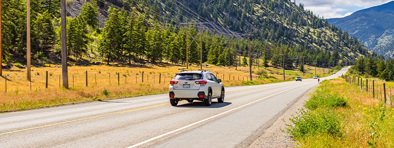 Car driving on a BC highway, representing ICBC Autoplan and optional car insurance coverage with Western Financial Group.