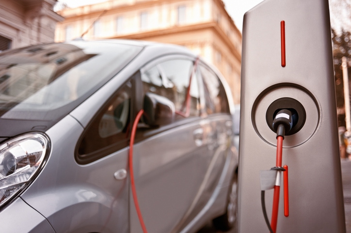 Electric, environmentally-friendly car being charged in charging station