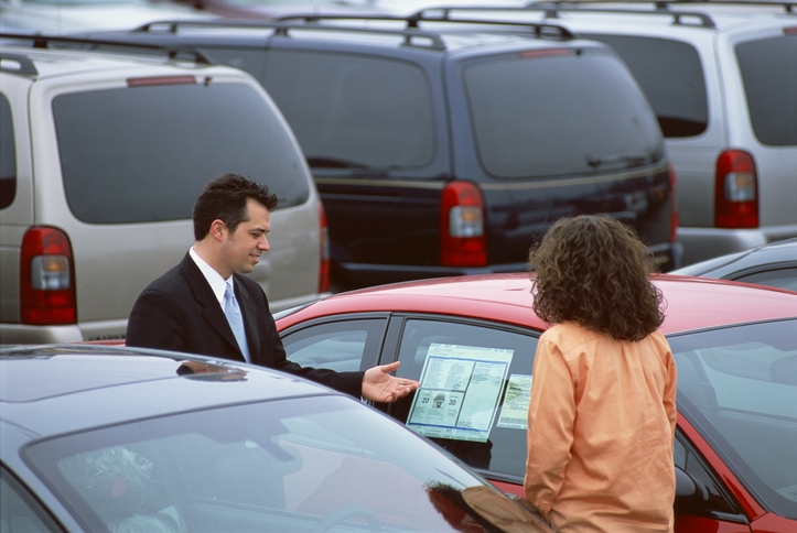 Young women in a car lot looking to purchase a vehicle