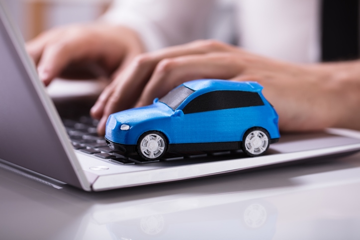 Toy car sitting on keyboard of laptop