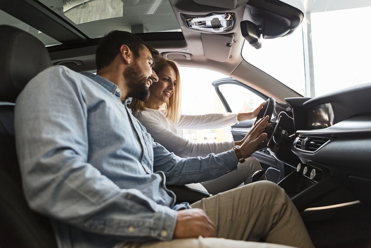 Young couple sitting in a new car