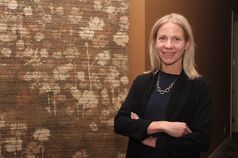 Dawn Ladds, vice president of commercial sales for Western Financial Group, stands in front of a patterned curtain with crossed, relaxed arms