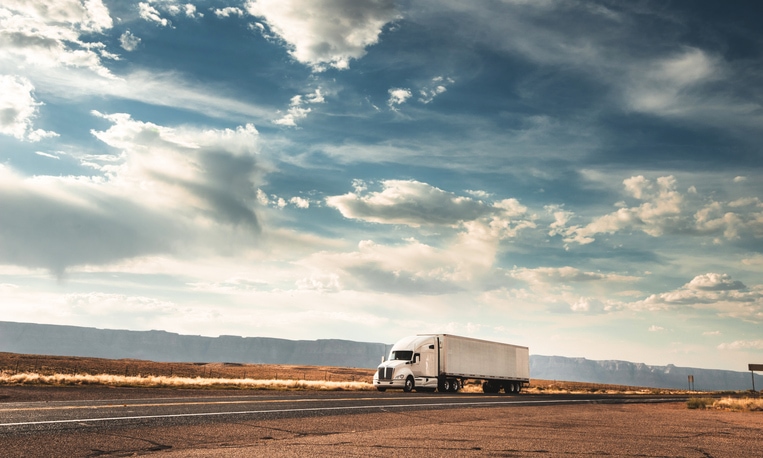 Semi truck driving along desert highway