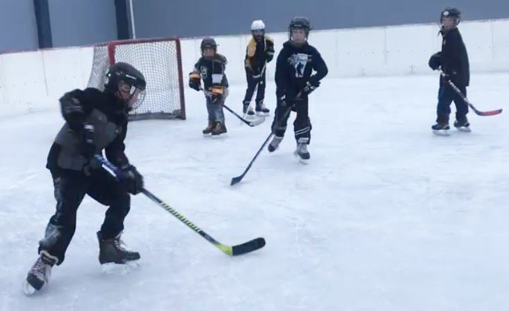 Children play on the outdoor ice rink in Hanna, Alberta