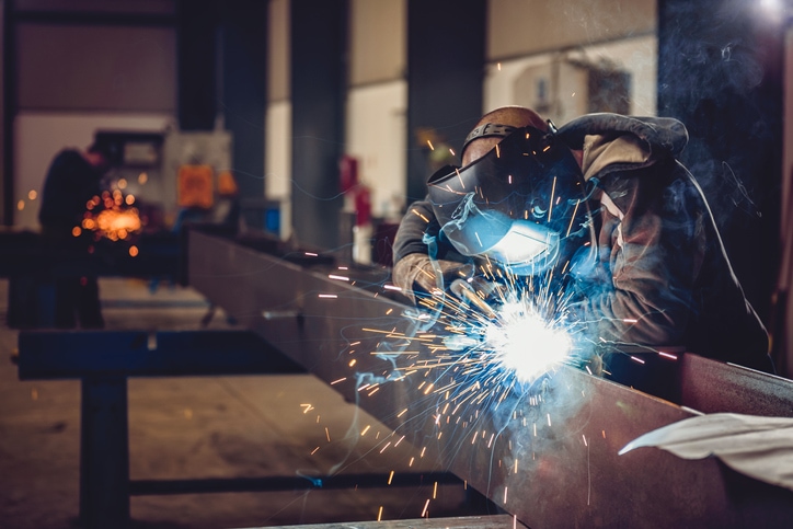 Welder welding metal bars together