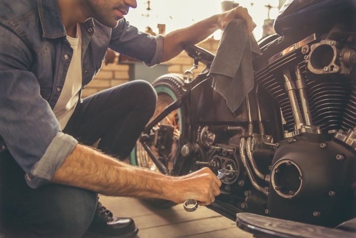 Man works on his motorcycle in his garage