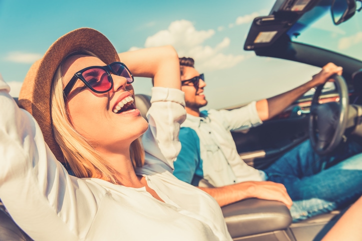 Young couple driving in a convertible in the summer