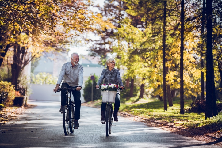 Retired couple biking down a street