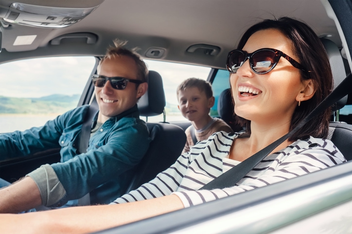 Young couple and their child driving in car