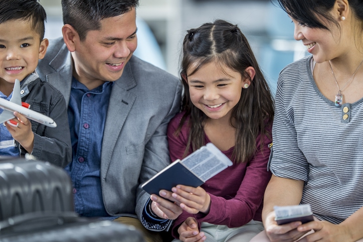 Asian family waits in airport to board their plane