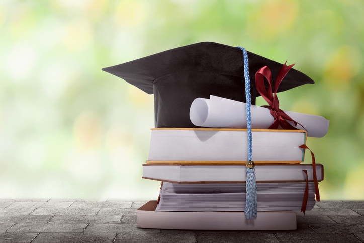 Textbooks and graduation hat stacked on top of each other