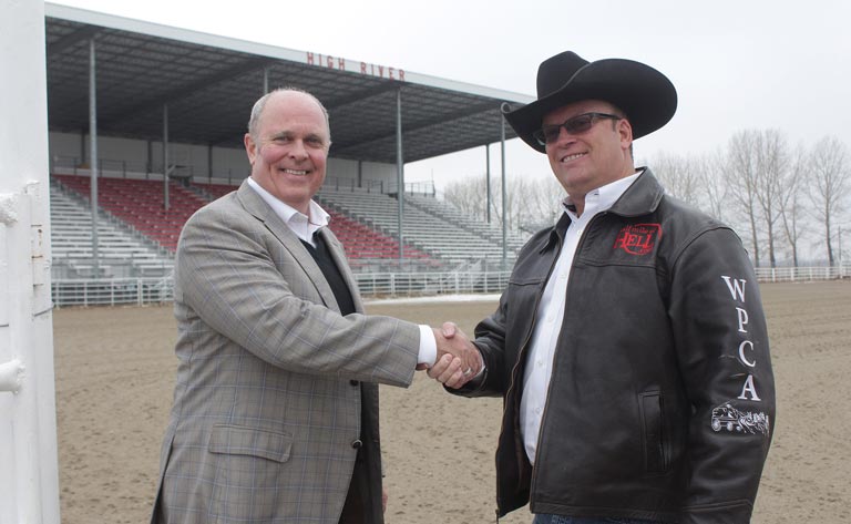 Rod Cunniam, Western Financial Group's head of digital and brand, shakes hands with Bryan Hebson, marketing director with the World Professional Chuckwagon Association (WPCA). 