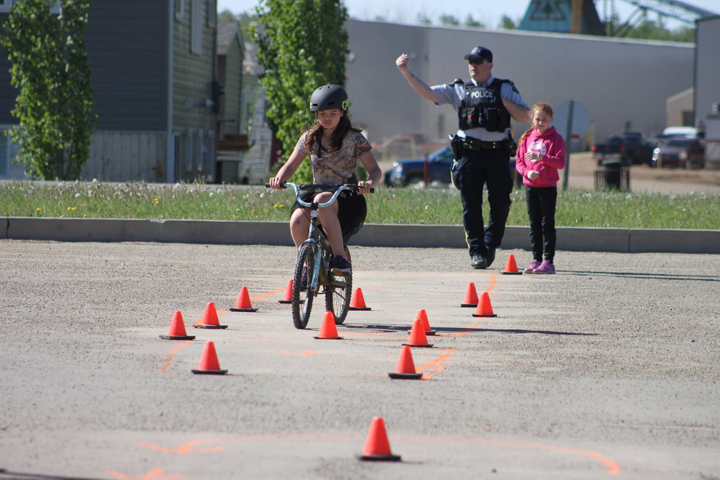 Sergeant Greg Beach assists a young rider during a bicycle safety rodeo